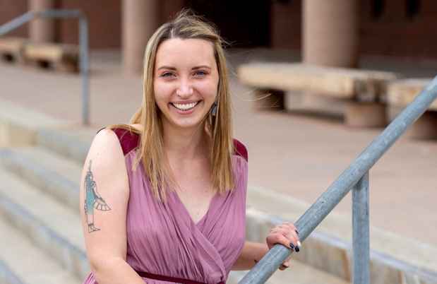 Participant Winter - person with long blond hair smiling on a stairwell outside