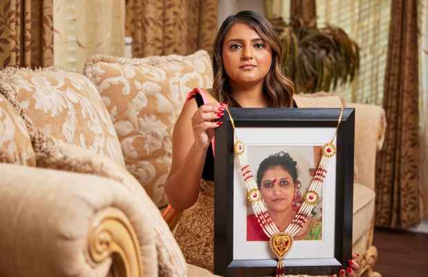 Participant Dimple - person with long wavy hair holding a framed photograph