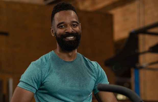 Participant Christopher - person with short dark hair and facial hair in a room with exercise equipment