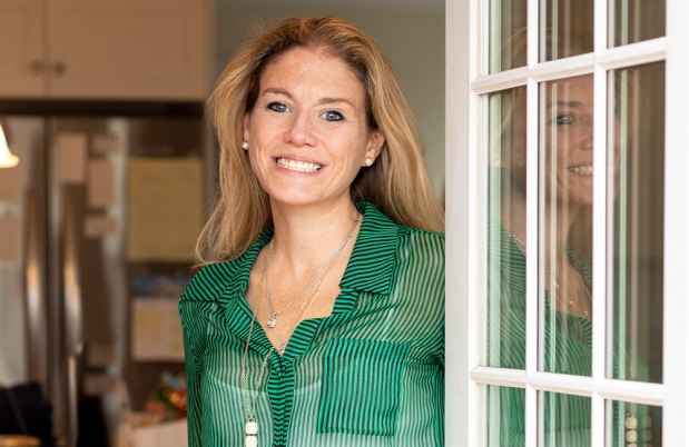 Participant Jenni - person with long blond hair smiling in a doorway