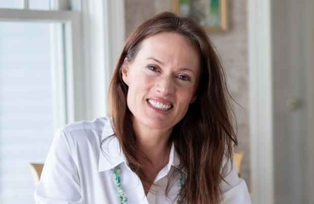 Participant Ashley - person with auburn hair smiling at a window