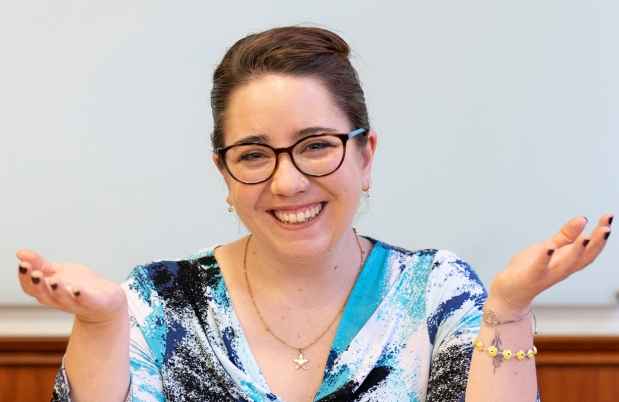 Participant Francisca - person with dark hair and glasses smiling in front of a whiteboard