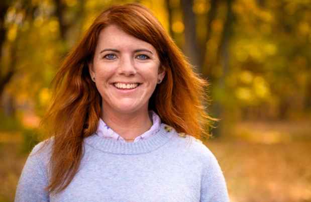 Participant Beth - person with shoulder-length red hair smiling outside