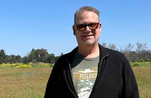 Participant Duncan - person with short dark hair wearing sunglasses and smiling outside