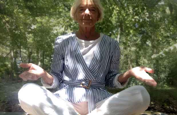 Participant Vicky sitting on the ground cross legged with her palms up