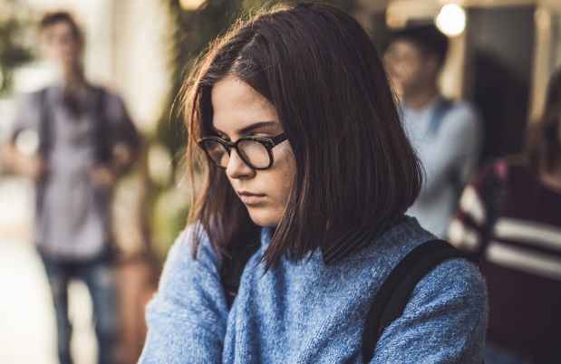 Young person looks anxious in a school hallway