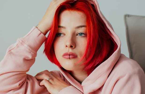 Teen girl with red hair leans on table