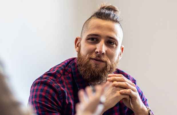 Person in plaid shirt talking to clinician