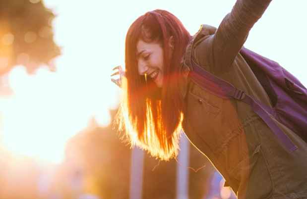 Teen dancing outside with sun glare behind