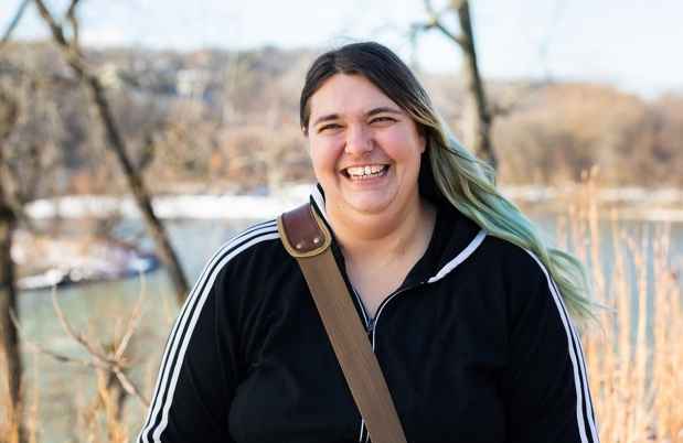 Participant Persephone - person with long hair dyed blue at the ends smiling outside