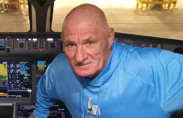 Deconstructing Stigma participant Paul - person in blue hoodie perches in airplane cockpit