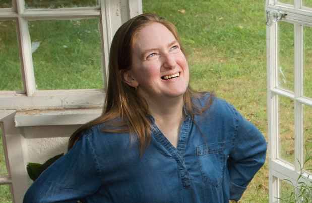 Deconstructing Stigma participant Amy - person stands in greenhouse