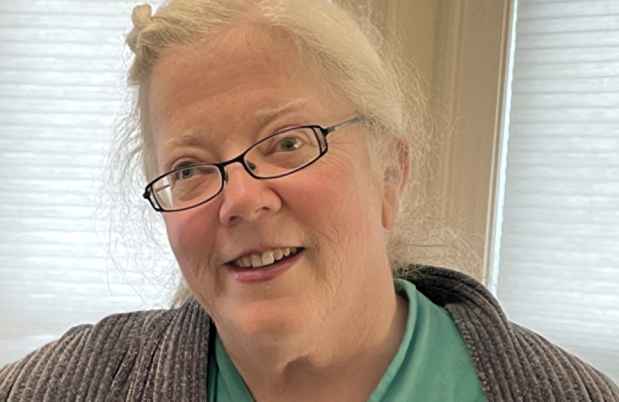 Deconstructing Stigma participant Francesca - person with white hair and glasses in green shirt and gray sweater