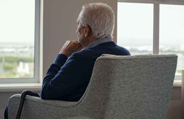 Person sitting in chair looking out a window