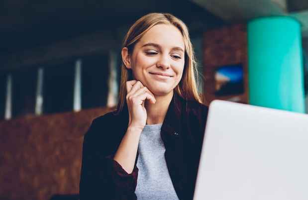 Person sits at desk working on laptop