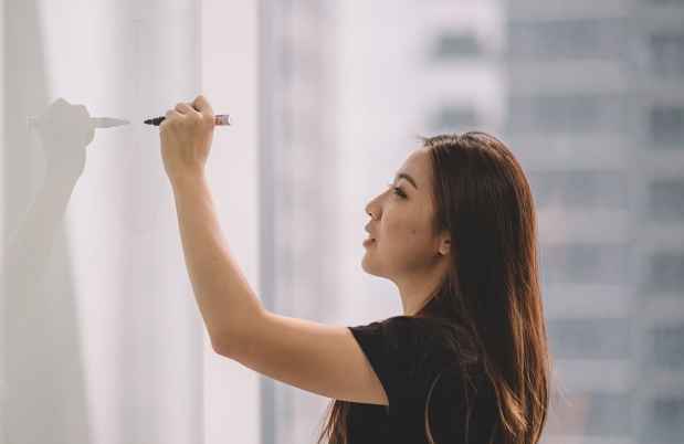 Employee writes on whiteboard