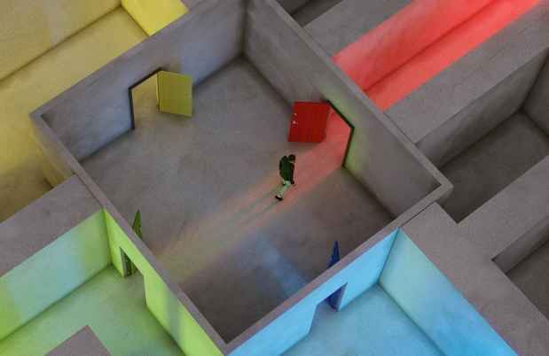 Figure walks through a multicolor lit up maze