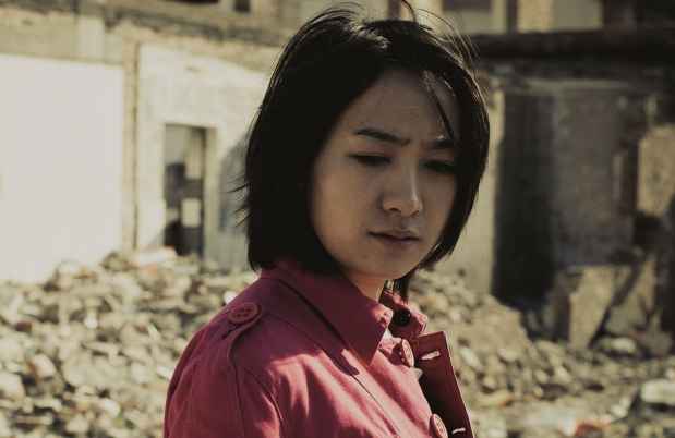 Person stands amidst rubble of a building