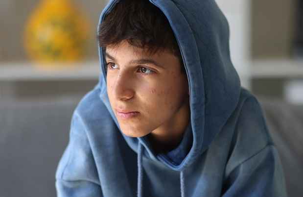 Young person in hoodie looking off