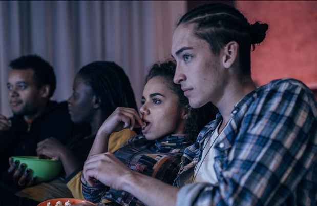Teens watch movie, eat popcorn