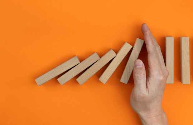 Hand between blocks on orange background