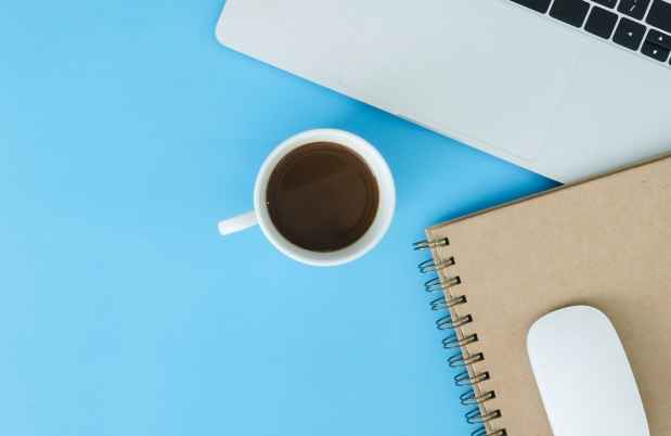 Coffee cup, mouse, laptop on blue background