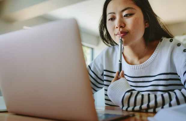 Young woman does schoolwork on laptop