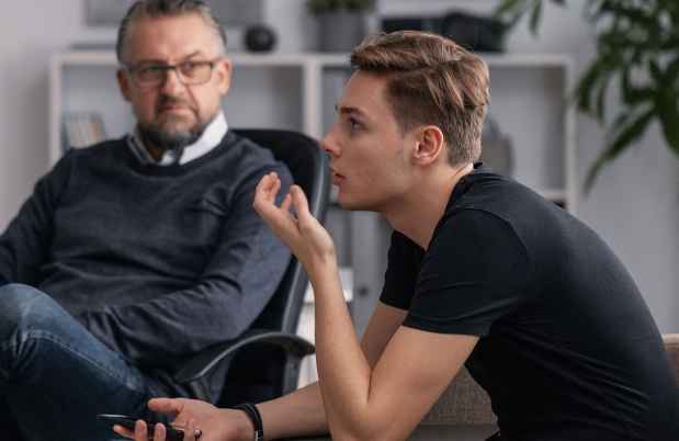 Teen boy in therapist office talking