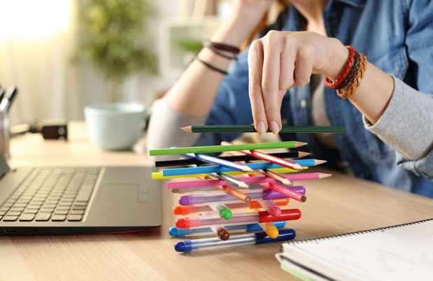 Balancing colorful pens and pencils on desk