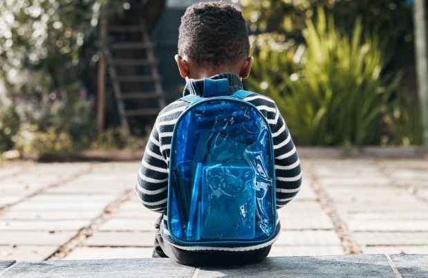 Child sitting with backpack
