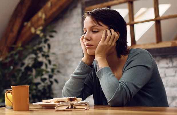 woman at a table looking sad