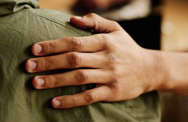 Comforting hand rests on a shoulder