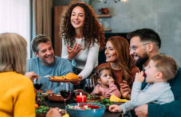 Group of people smiling around a table with food