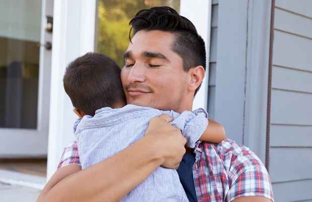 Man hugging son and smiling