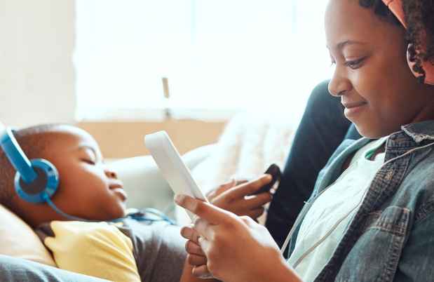 Teen and child listen to music on headphones