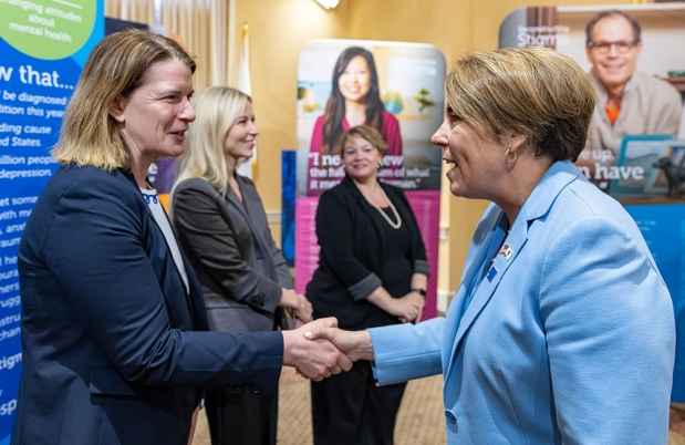 Shaking hands with Governor with poster panels on display