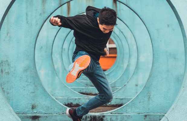 Teen kicking in a skateboard tunnel