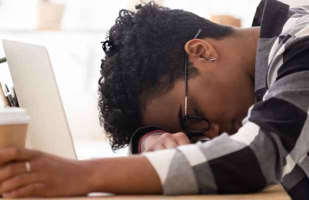 Person sleeping with head down on table