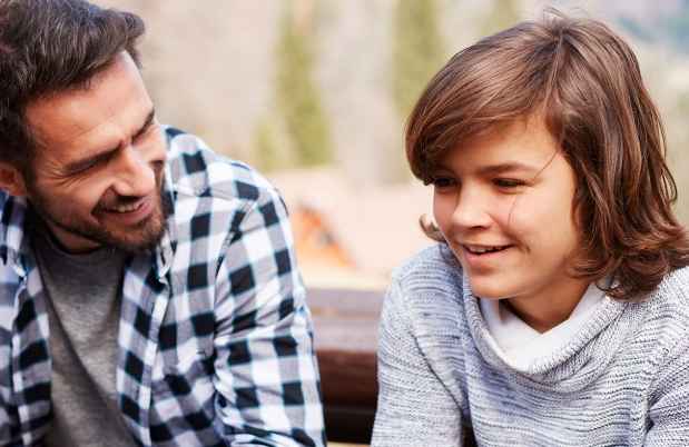 Parent and teen sit and talk on a bench