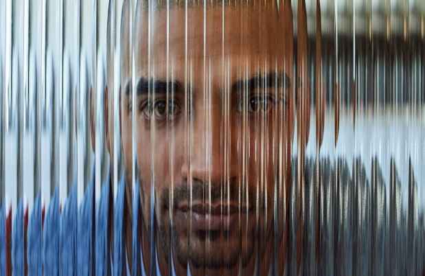 Blurred face behind lined glass