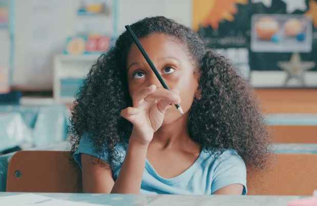 Child fiddles with pencil in classroom