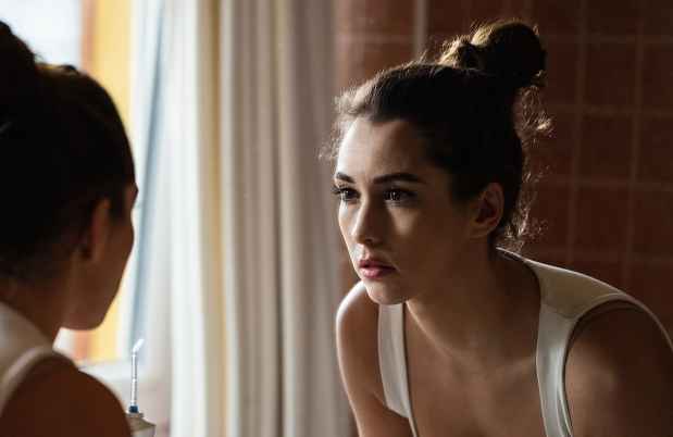 Person looks at self in the mirror