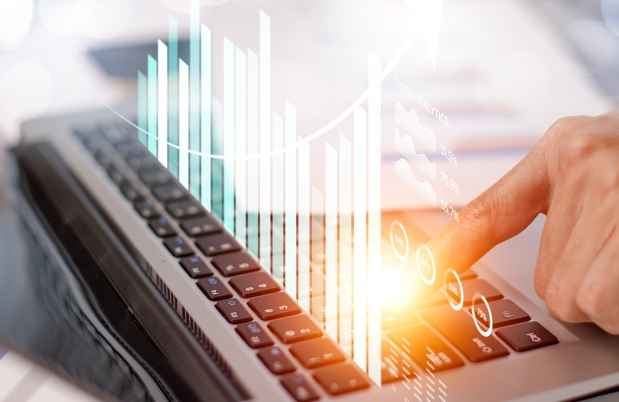Graphic of charts over hand pointing at laptop