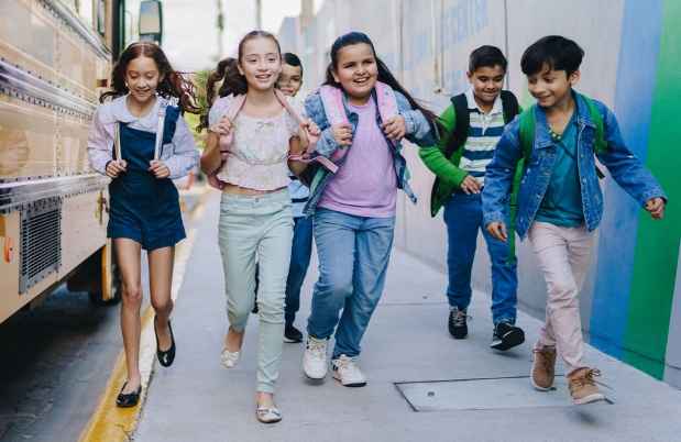 kids running by school bus