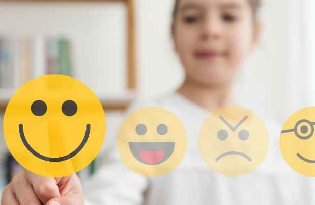 Child points at a scale of emojis