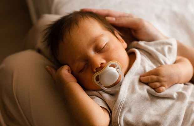 Baby sleeps on parent knees