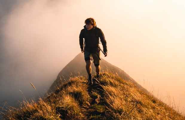 Hiker climbing and surrounded by clouds