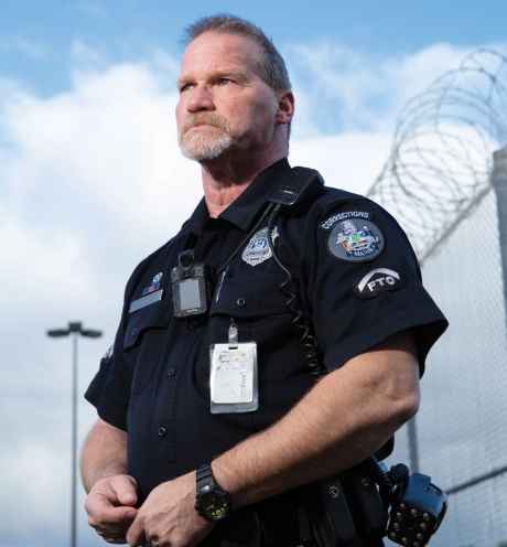 Participant Kevin - person in police uniform in front of a bright blue sky with clouds