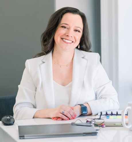 Participant Lauren - person with dark hair in a white blazer smiling at a table