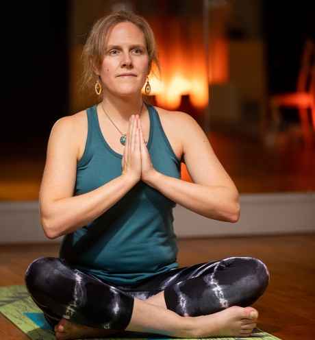 Participant Sandy - person with long wavy hair holding a yoga pose